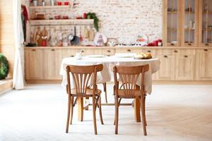 elegante interior de cocina con mesa y sillas de madera foto