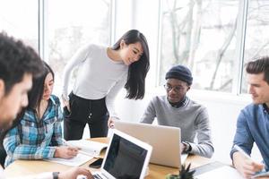 jóvenes profesionales trabajando en computadoras portátiles en una oficina foto