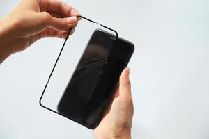 Close-up of person fixing cracked smartphone cover photo