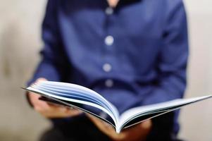 A businessman in a blue shirt with open notebook photo