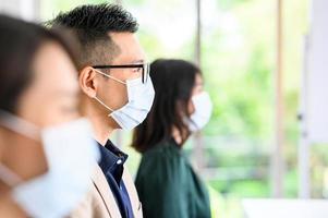 Grupo de personas asiáticas con mascarillas protectoras por seguridad foto