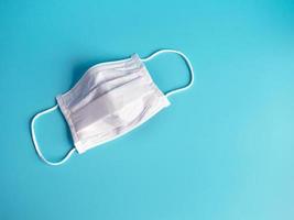 Close up of white surgical face mask on blue background photo