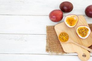 Fresh passion fruits on white wooden table with cutting board  photo