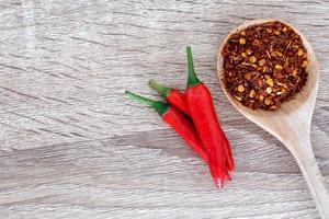 chiles frescos y triturados en mesa de madera foto