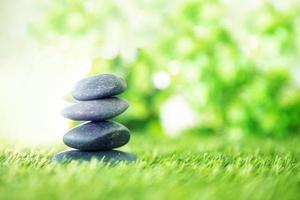 Stones stacked together on green grass photo