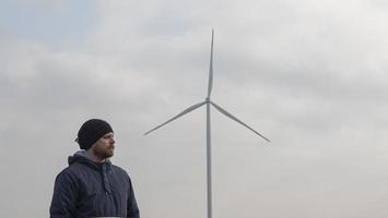 Man stands against background of windmill photo