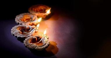 Lit diya lamps in dark room photo