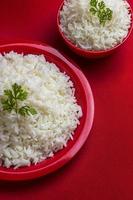 Cooked basmati rice on red background photo