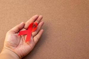 Red ribbon on open hand for world aids day  photo