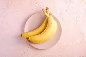 Bananas on pink textured background photo