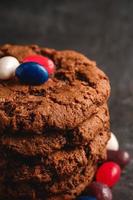 Chocolate cookies stacked on textured dark black background photo