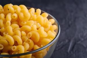 Cavatappi golden wheat curly pasta on textured dark black background photo