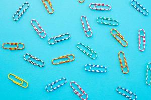 Paper clips on color background photo