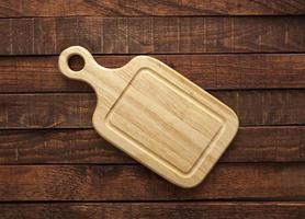 Cutting board on wooden table photo