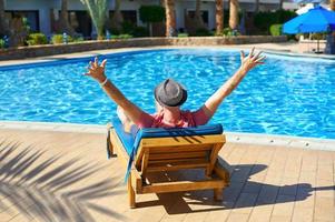Young man laying on a sun lounger at hotel  photo