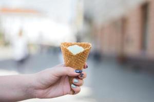 Girl's hand holds vanilla ice cream photo