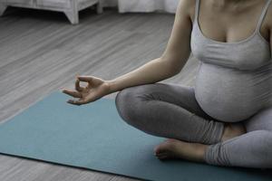 Pregnant woman practices yoga photo