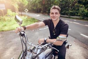 joven atractivo posa con motocicleta foto