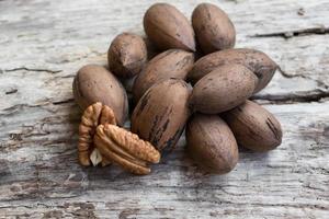 nueces pecan en mesa de madera vieja foto