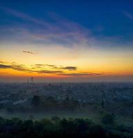 Sunset over foggy city photo