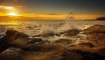 Ocean waves crashing on rocky shore photo