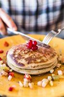 Cherry pancakes on yellow plate photo