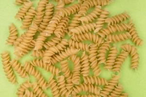 Rotini pasta on green background photo