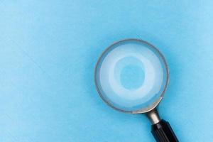 Magnifying glass on blue background photo