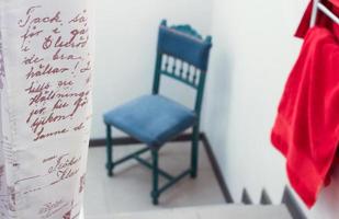 Words on curtain next to blue chair and red towel photo