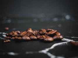 Coffee beans on black marble surface photo