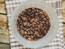 Coffee beans in plastic cup photo