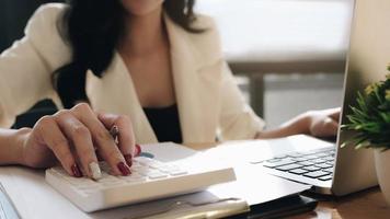 Close-up of businesswoman using calculator photo