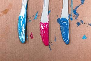 Acrylic paints applied on three plastic knives photo