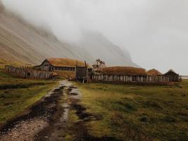 cabaña y camino de tierra al lado de la montaña de niebla foto