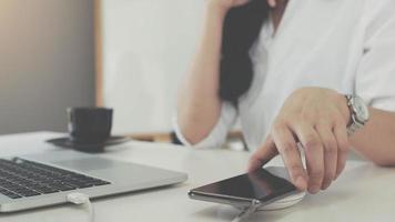 Woman putting mobile phone on wireless charger photo