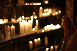 Person prays before candles