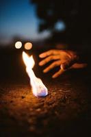 Person reaching for flaming stone photo