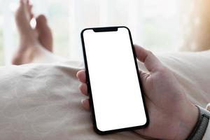 Close-up of person holding phone in bed photo