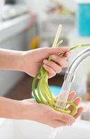 Person washing green onions photo