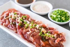 carne de cerdo fresca en rodajas con coberturas foto