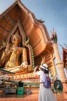 turista tomando fotografía del templo budista