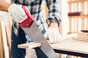 Close up portrait of craftsman cutting lumber in work shop