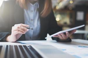 Businesswoman sits at a coffee shop to review work documents photo