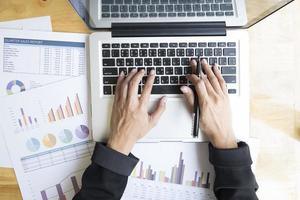 Table top view of businessperson using a laptop at work photo