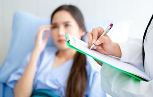 Close-up of Asian female doctor at work with patient  photo