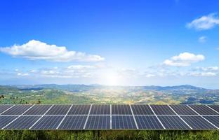 A power solar panel field sits atop a mountain under blue skies