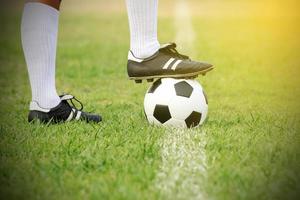 Soccer player standing with ball on the field  photo