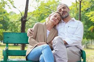 Couple relaxing on park bench photo