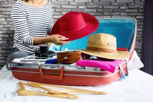 Young woman packing clothes for travel  photo