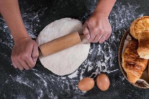 Male hands rolling out dough photo